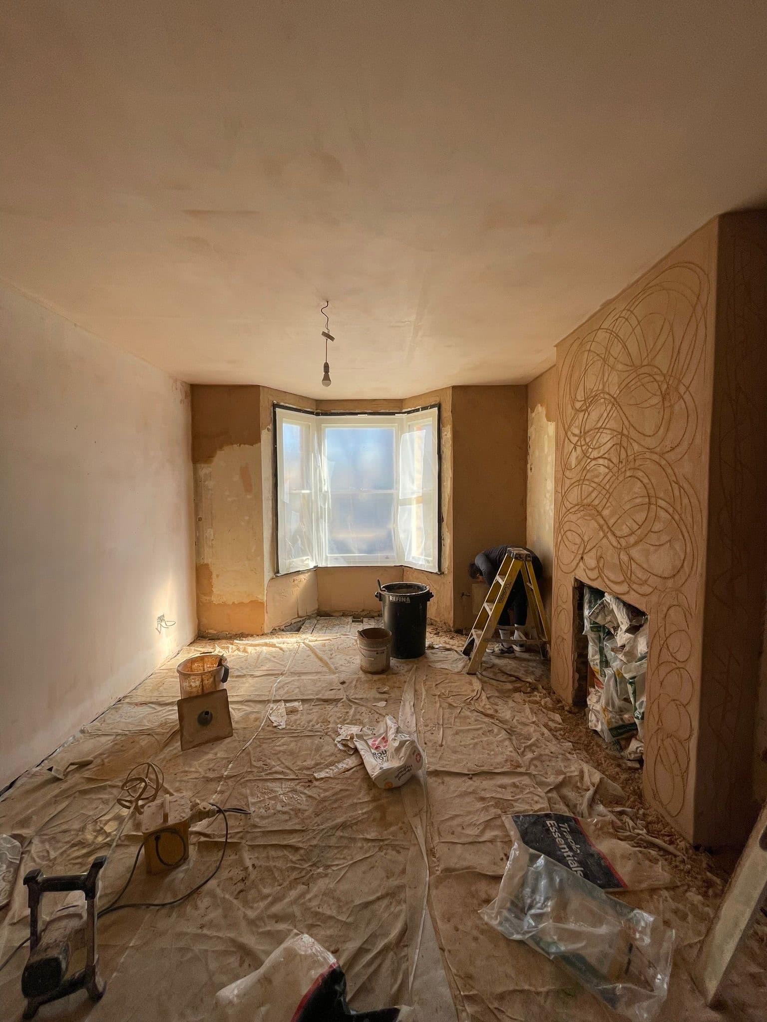 David Clement plastering an interior room